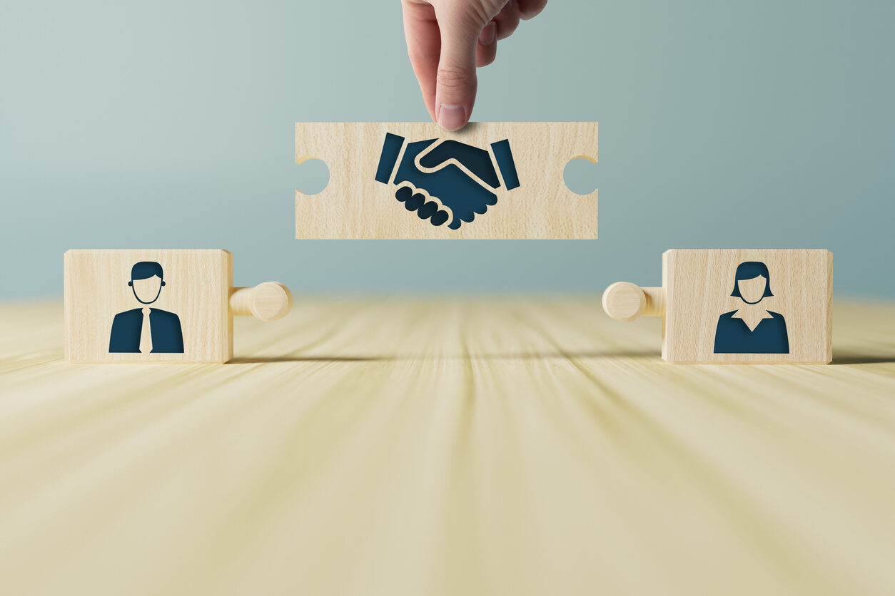 Puzzle pieces symbolizing a man and a woman being connected by a handshake piece, illustrating the concept of required mediation in Florida legal proceedings.