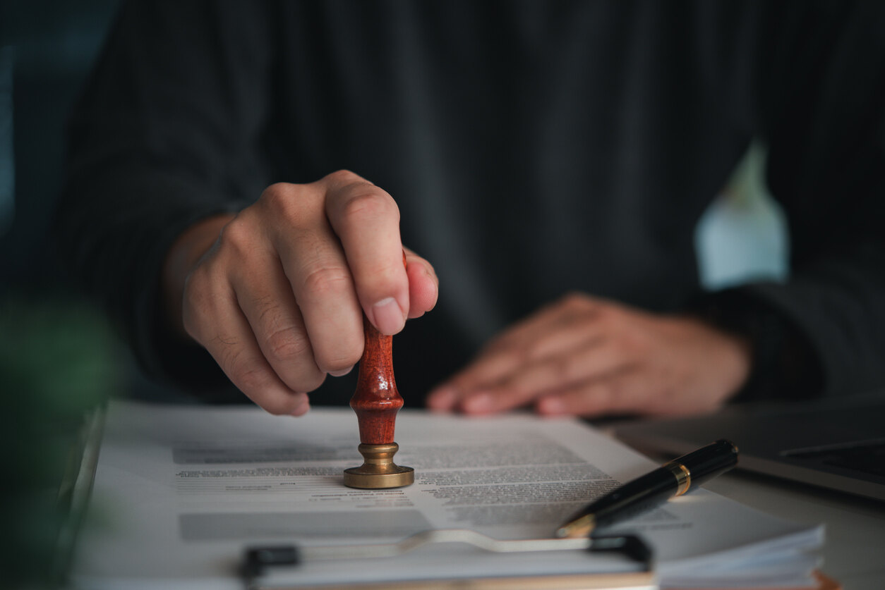 Close-up of a person stamping a legal document with a red stamp, symbolizing legal action or the enforcement of a custody agreement in Port St. Lucie.