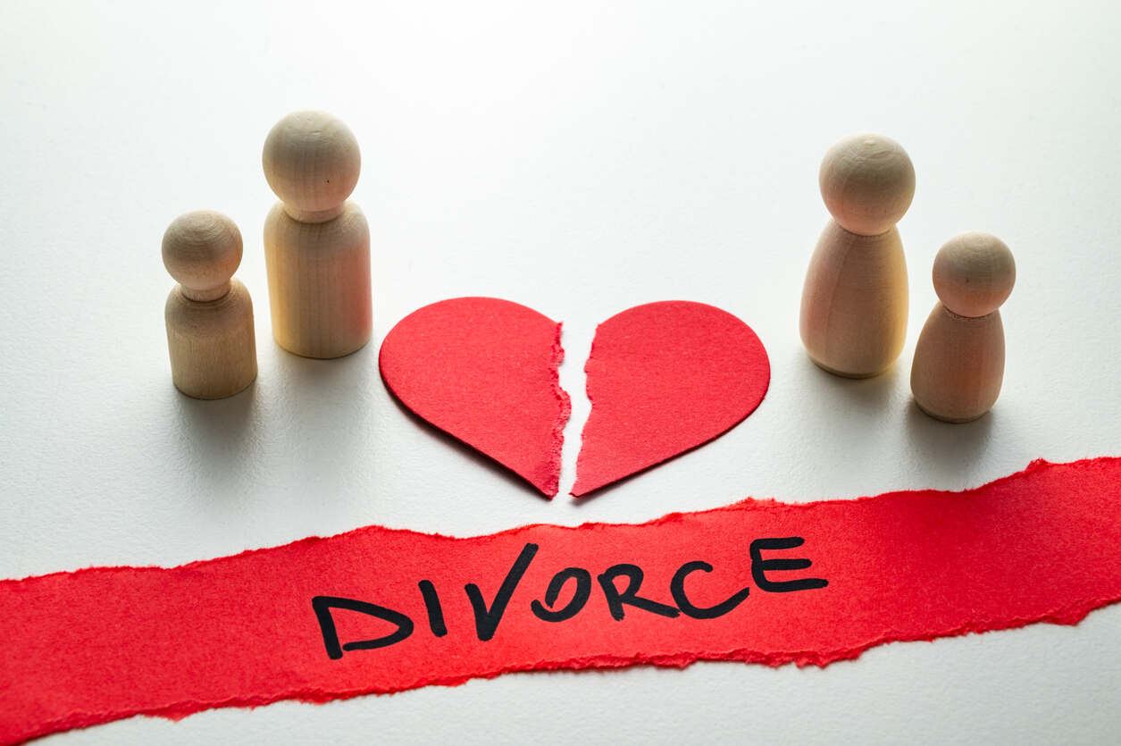 Torn red heart between two separated pairs of wooden family figures with the word “Divorce,” symbolizing marital separation and divorce rates in Port St. Lucie.